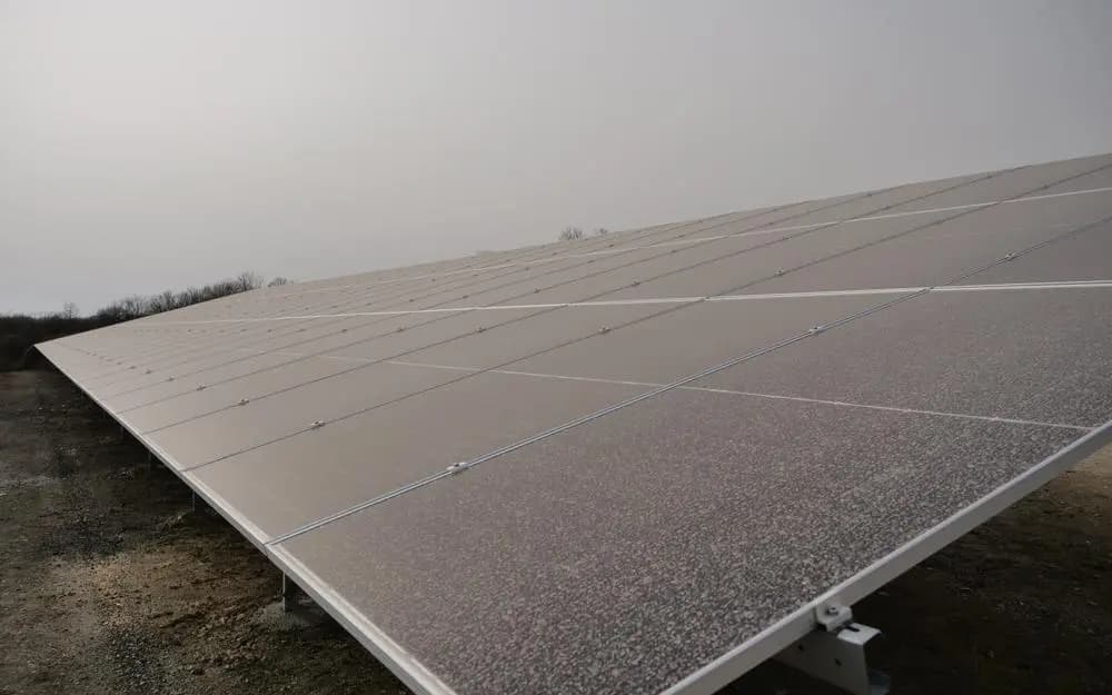 Panneaux solaires encrassés par un dépôt gris de poussière, réduisant la production.